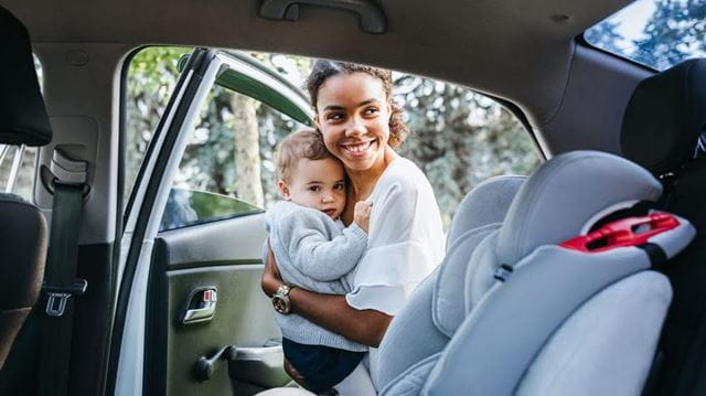 Woman putting child in car